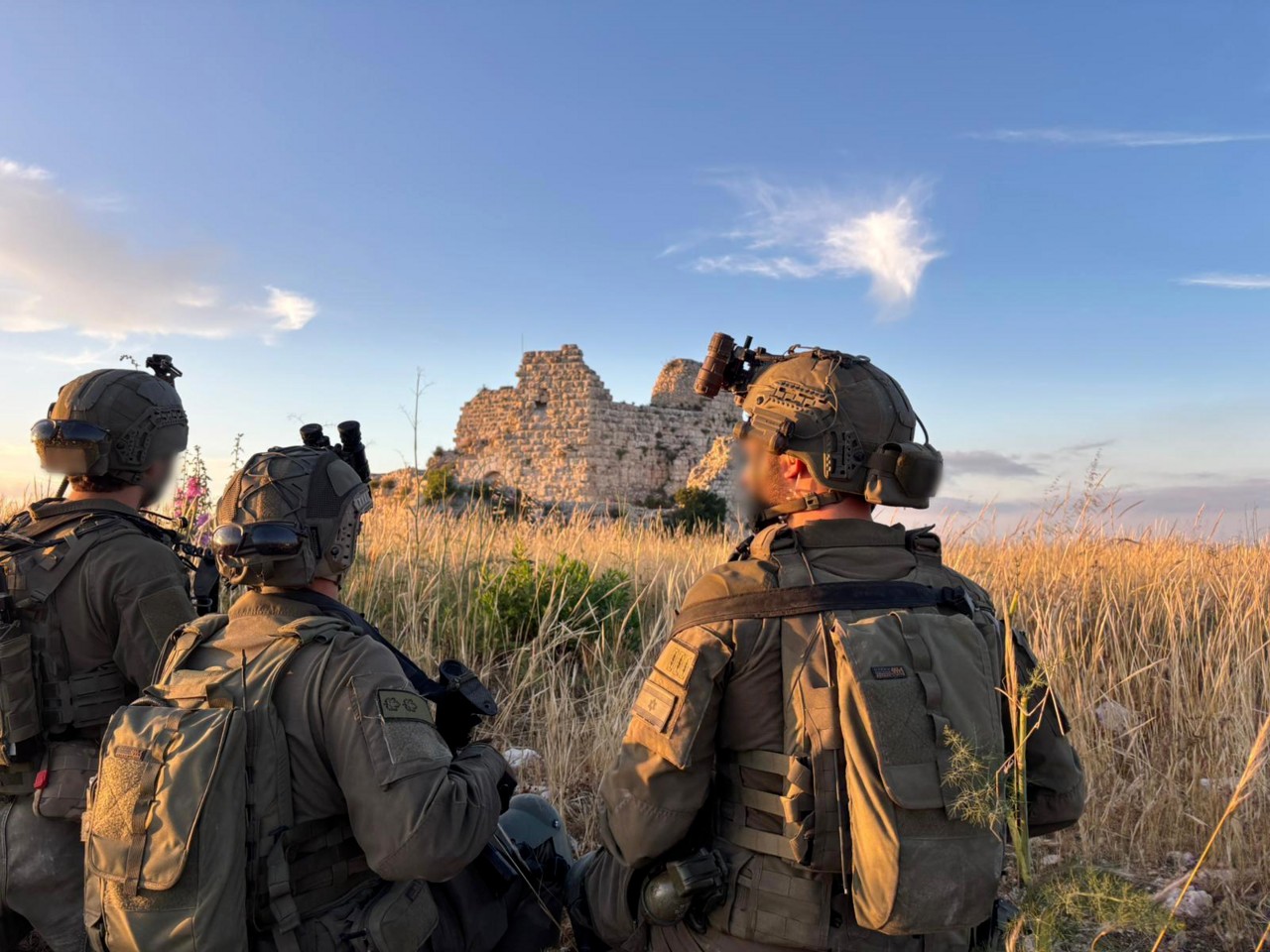 Israeli soldiers in a field at dusk looking toward the ruins of Beaufort Castle